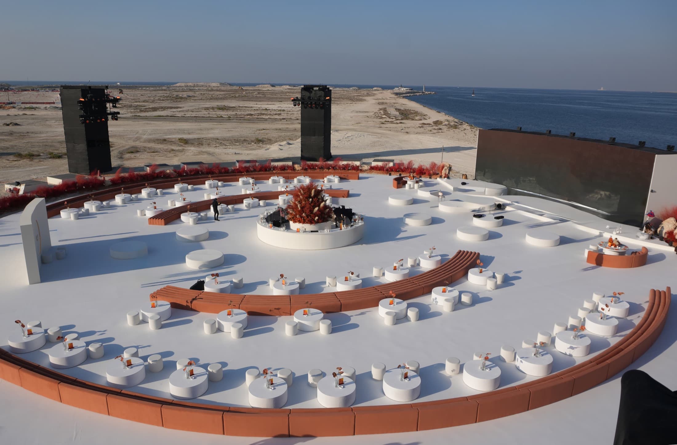 A circular majlis on the Abu Dhabi waterfront, concentric rings of seating facing the sea
